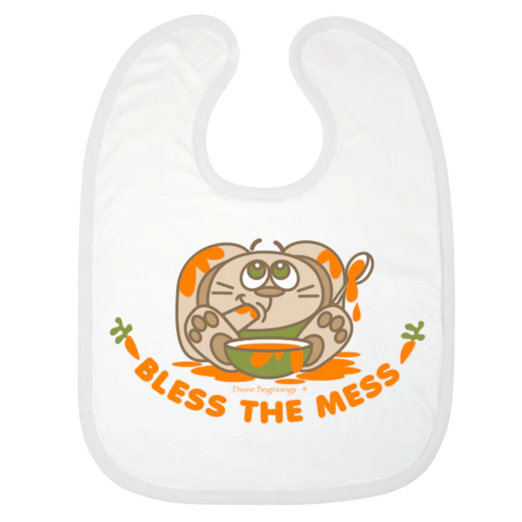 A white reversible bib with a cartoon bunny design and the phrase 'BLESS THE MESS' printed on the front.